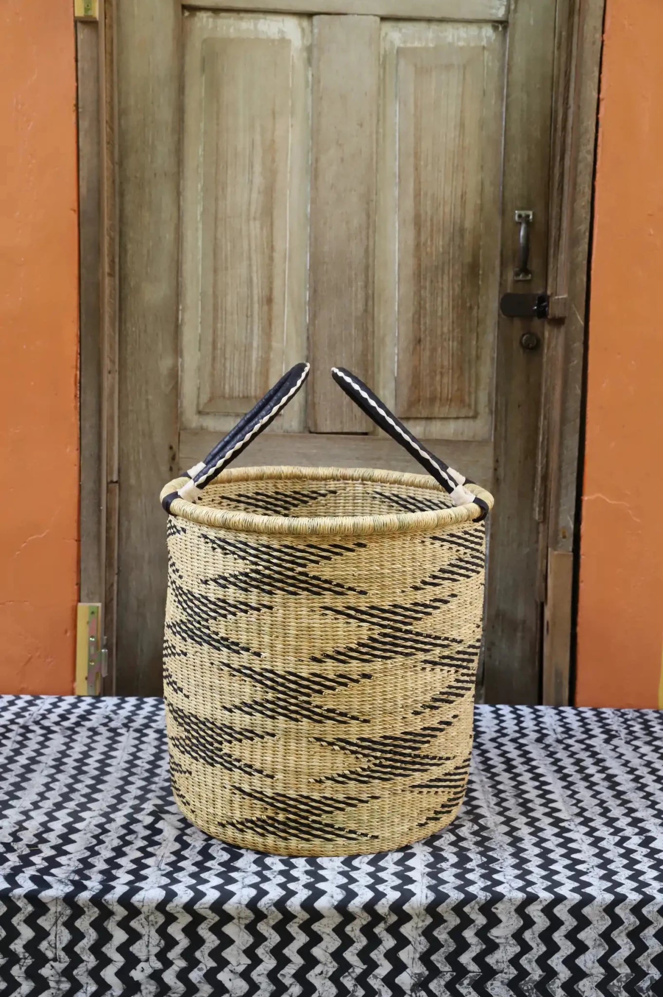 Open Laundry Basket (Small) by The Baba Tree. Handwoven elephant grass storage with leather handles. Bolgatanga artisan decor.