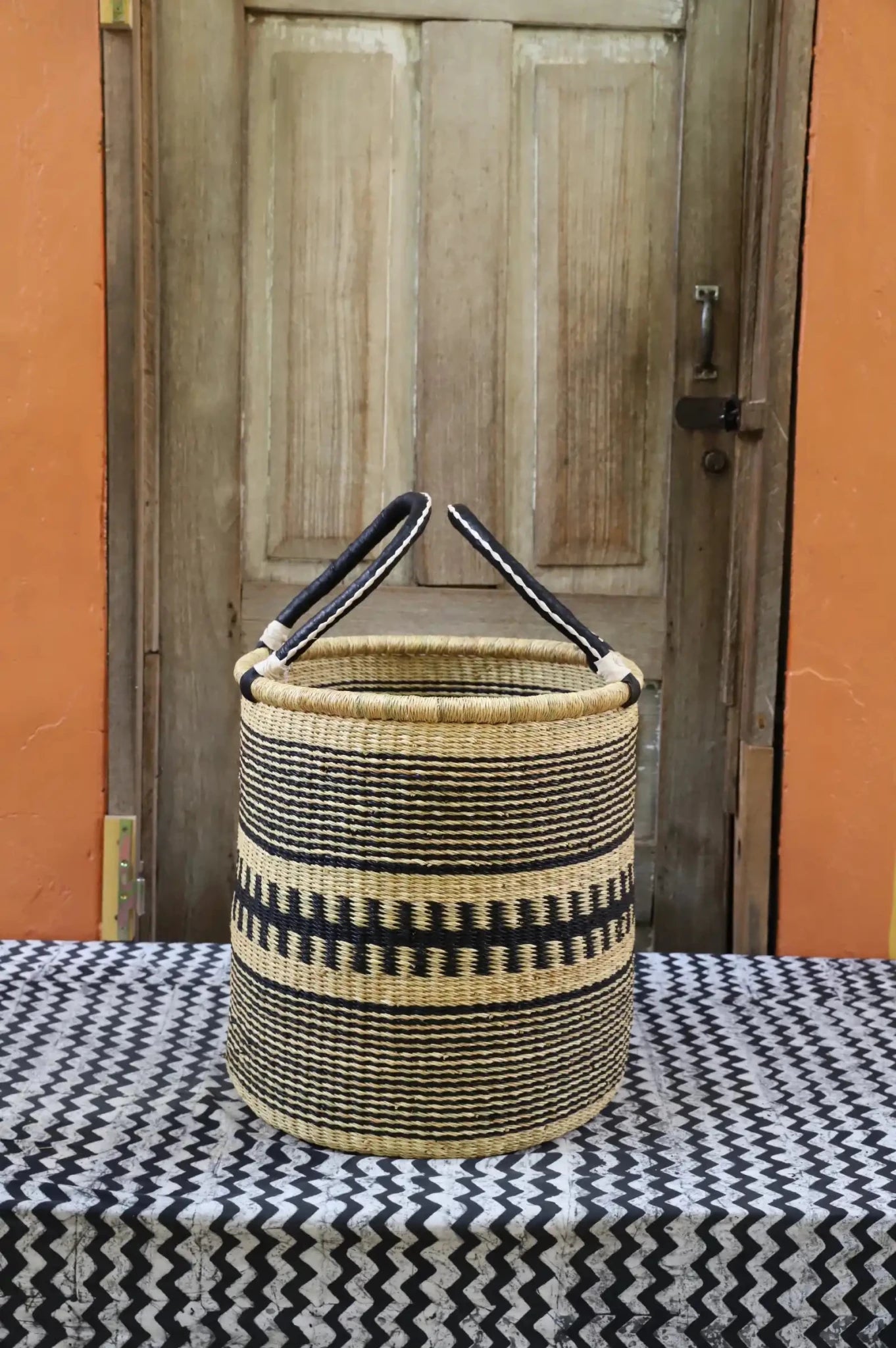 Open Laundry Basket (Small) by The Baba Tree. Handwoven elephant grass storage with leather handles. Bolgatanga artisan decor.
