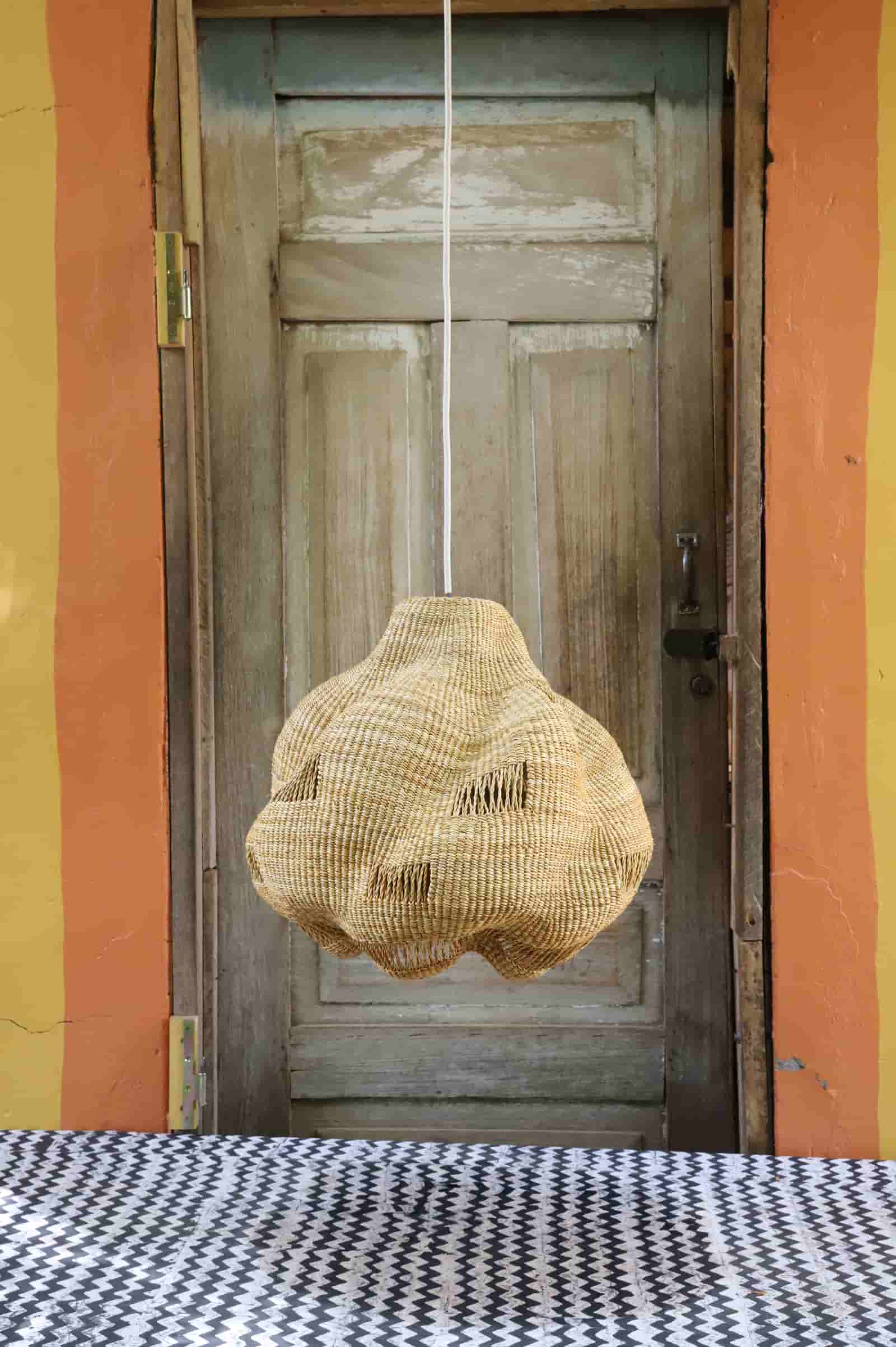 Woven basket hanging in front of a wooden door with a colorful wall background