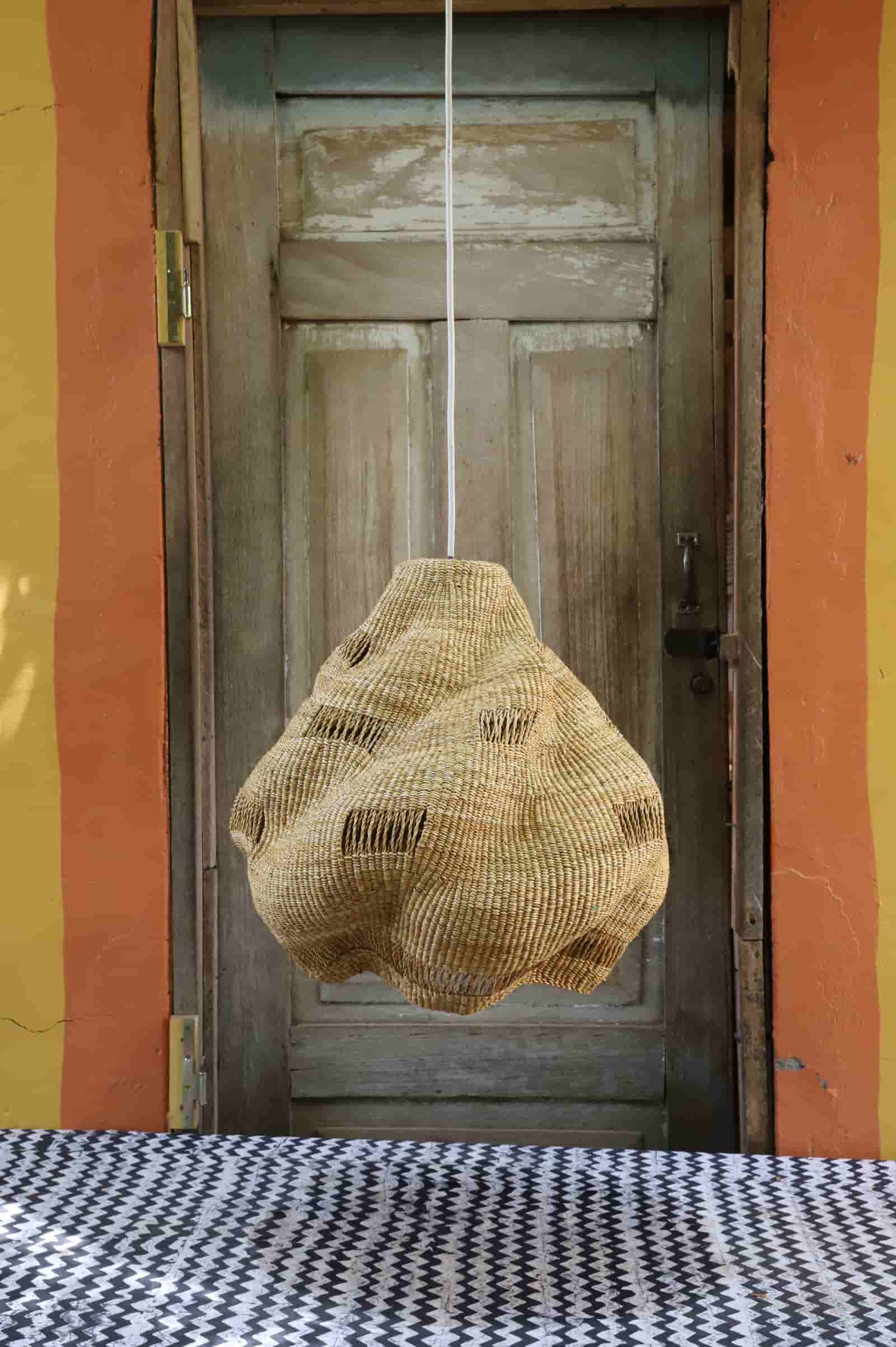 Woven basket hanging on a door with a colorful wall in the background