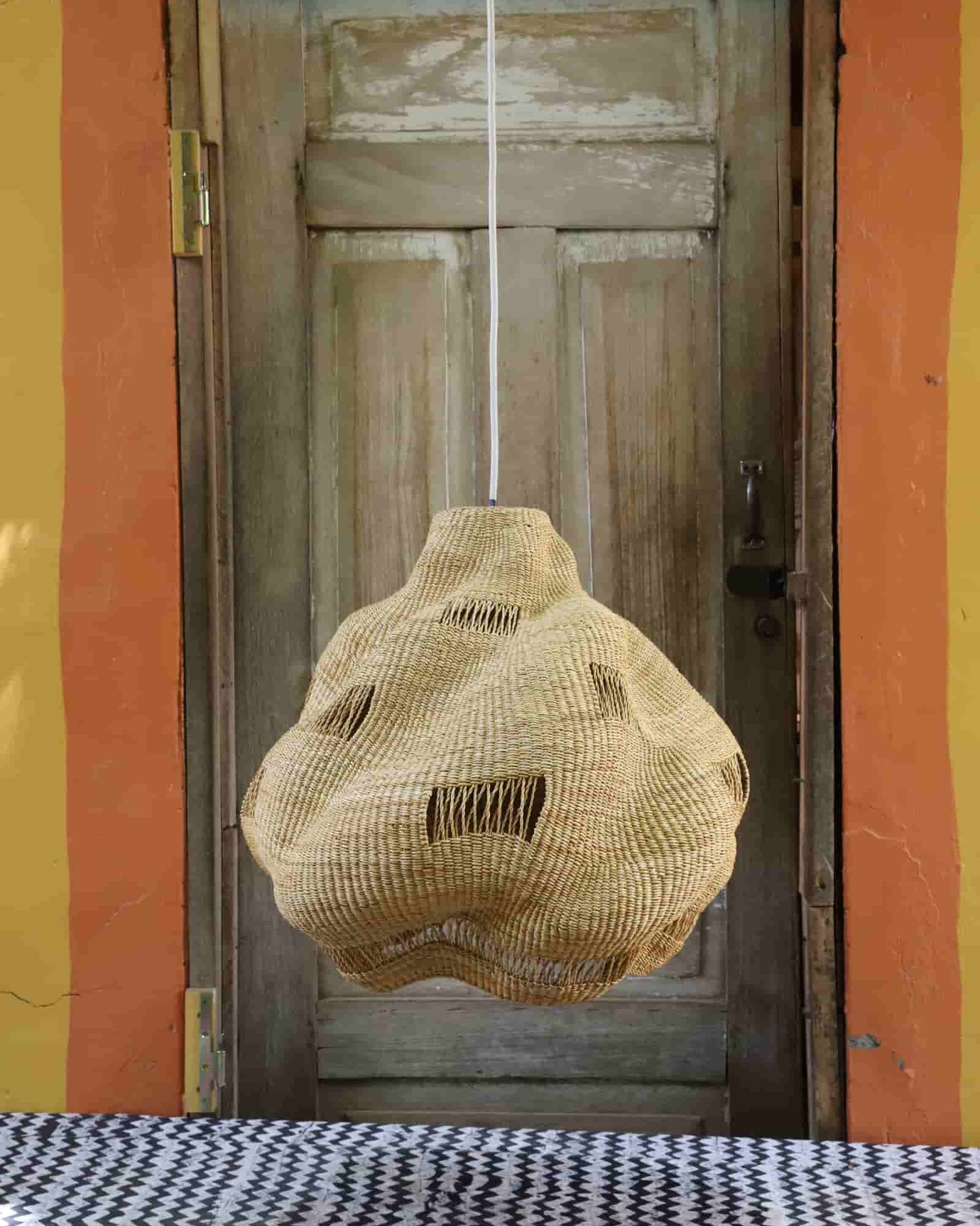 Woven basket hanging in front of a wooden door with a colorful wall background