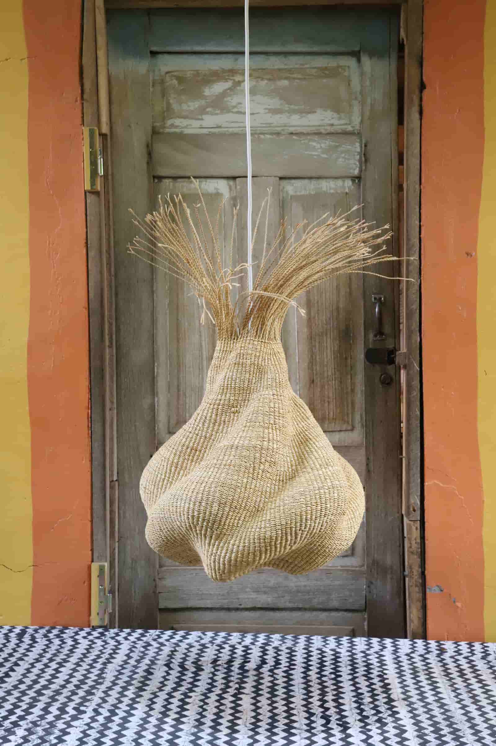 Woven basket hanging on a door with a checkered tablecloth in the foreground