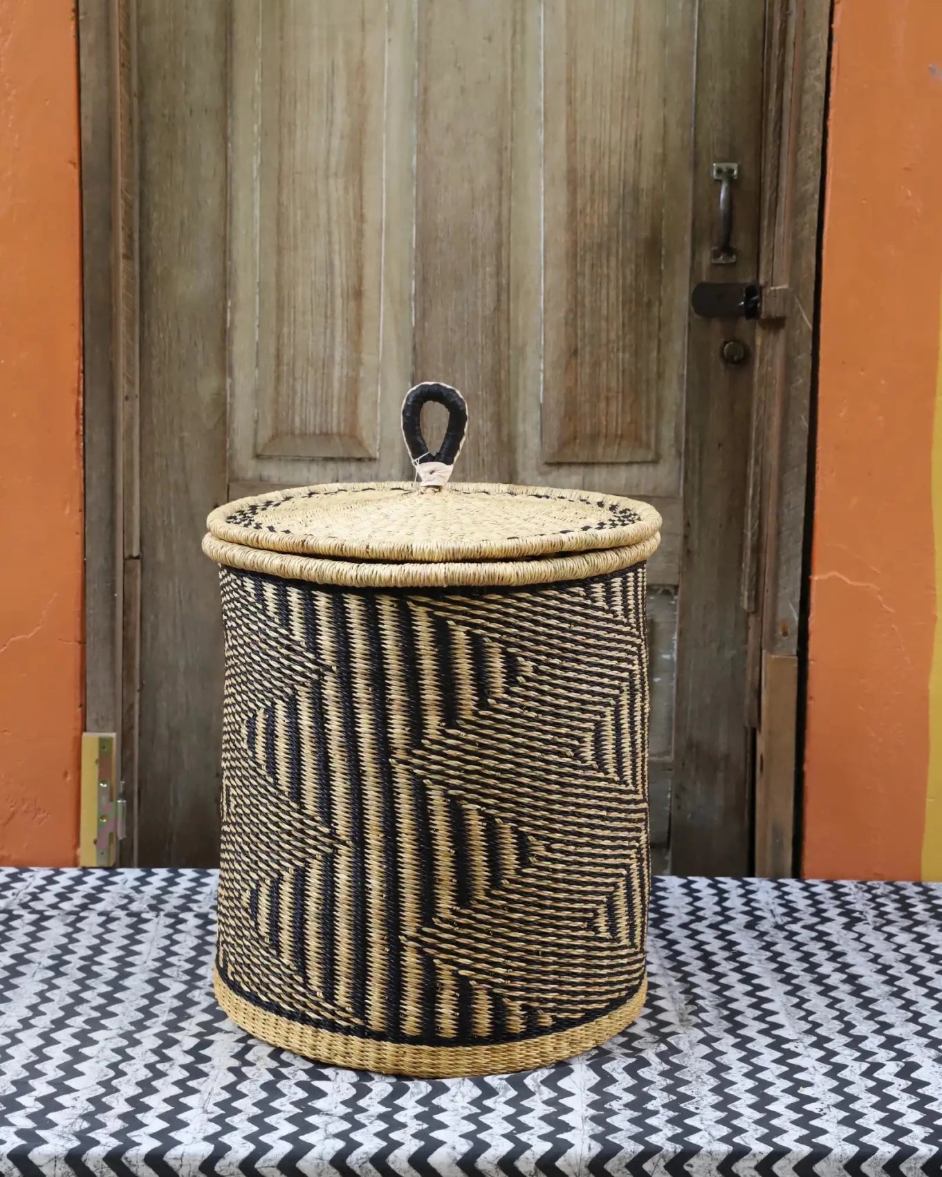 Lidded Laundry Basket with coil (Small) by The Baba Tree. Handwoven elephant grass with leather handle. Premium Bolgatanga artisan decor.