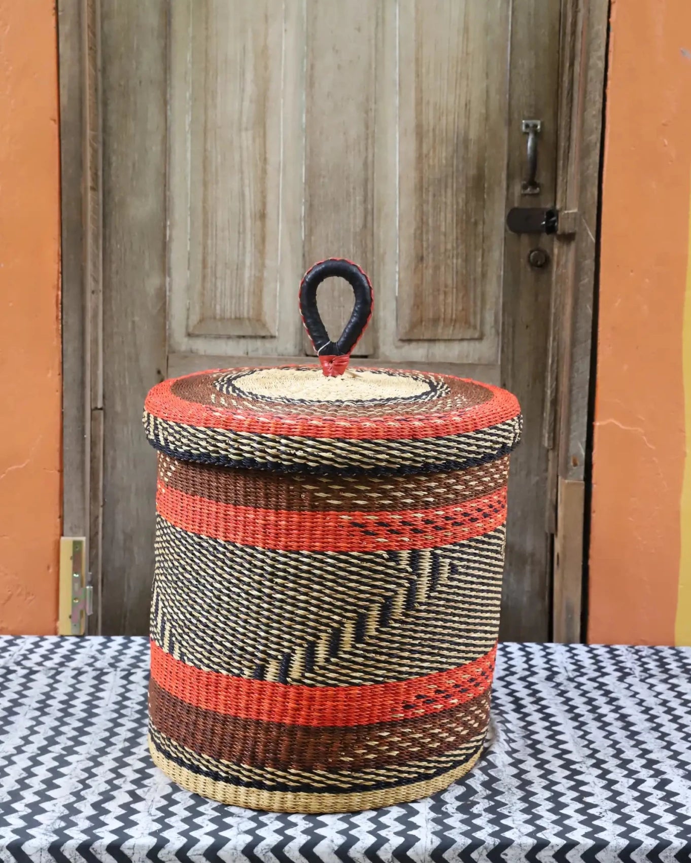 Lidded Laundry Basket (Medium) by The Baba Tree. Handwoven elephant grass with leather handle. Premium Bolgatanga artisan decor.