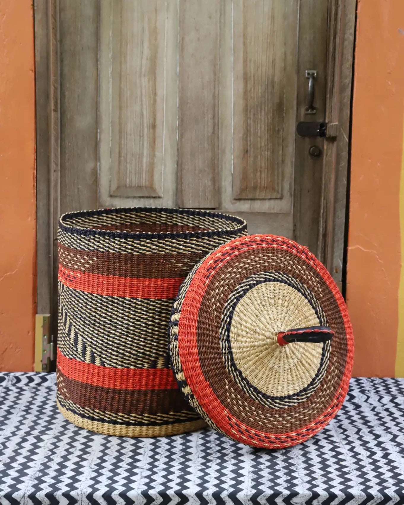 Lidded Laundry Basket (Medium) by The Baba Tree. Handwoven elephant grass with leather handle. Premium Bolgatanga artisan decor.