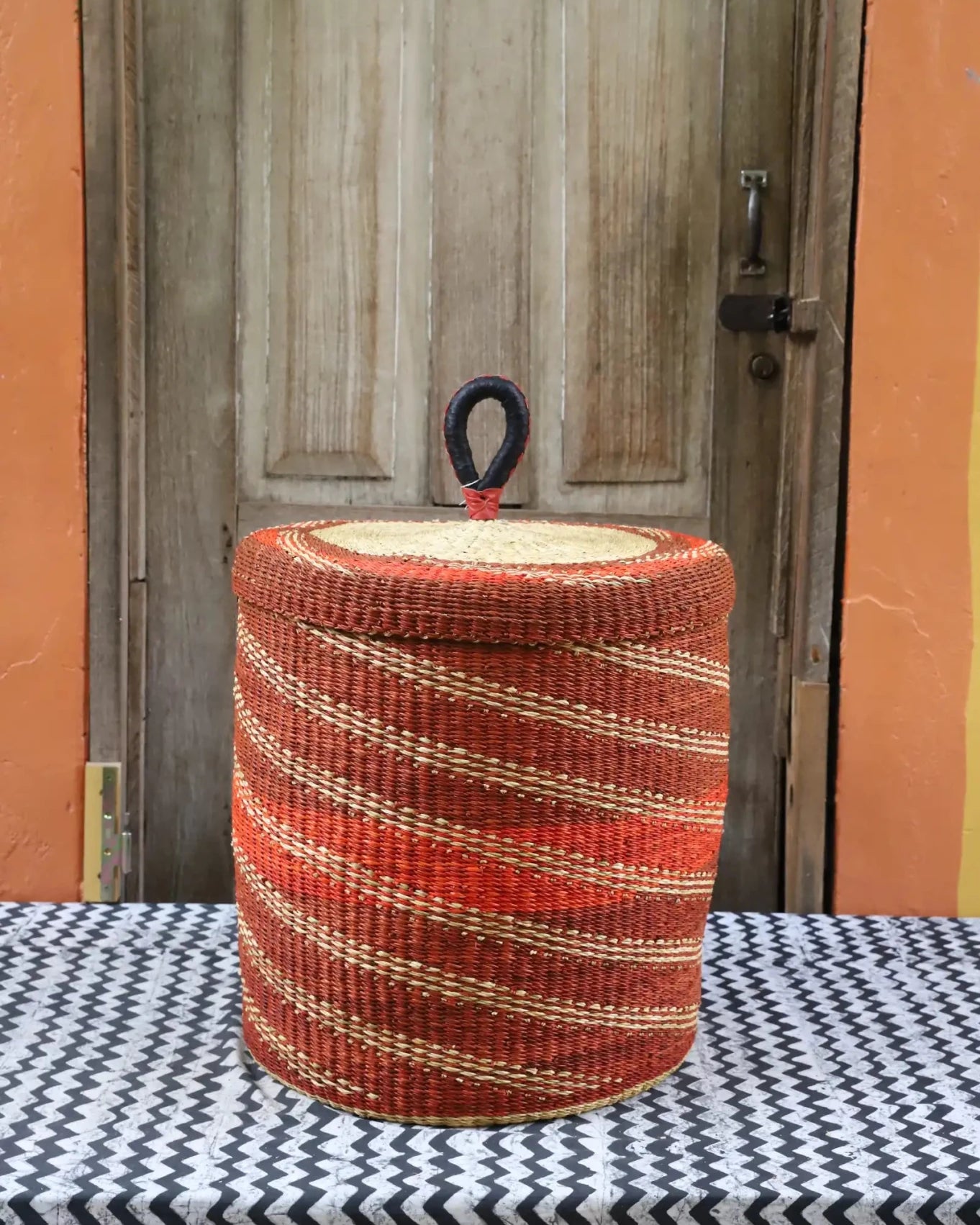Lidded Laundry Basket (Medium) by The Baba Tree. Handwoven elephant grass with leather handle. Premium Bolgatanga artisan decor.