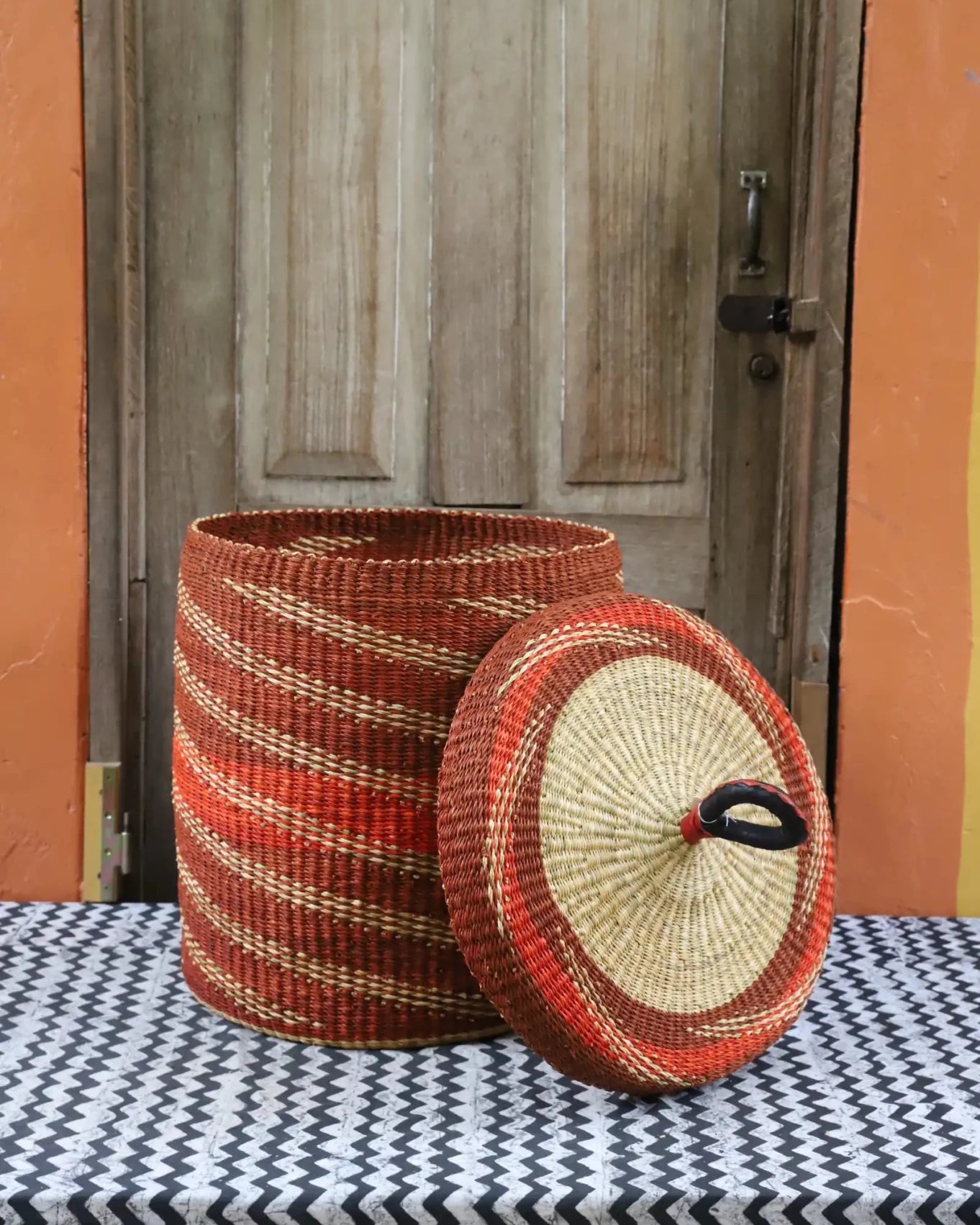 Lidded Laundry Basket (Medium) by The Baba Tree. Handwoven elephant grass with leather handle. Premium Bolgatanga artisan decor.