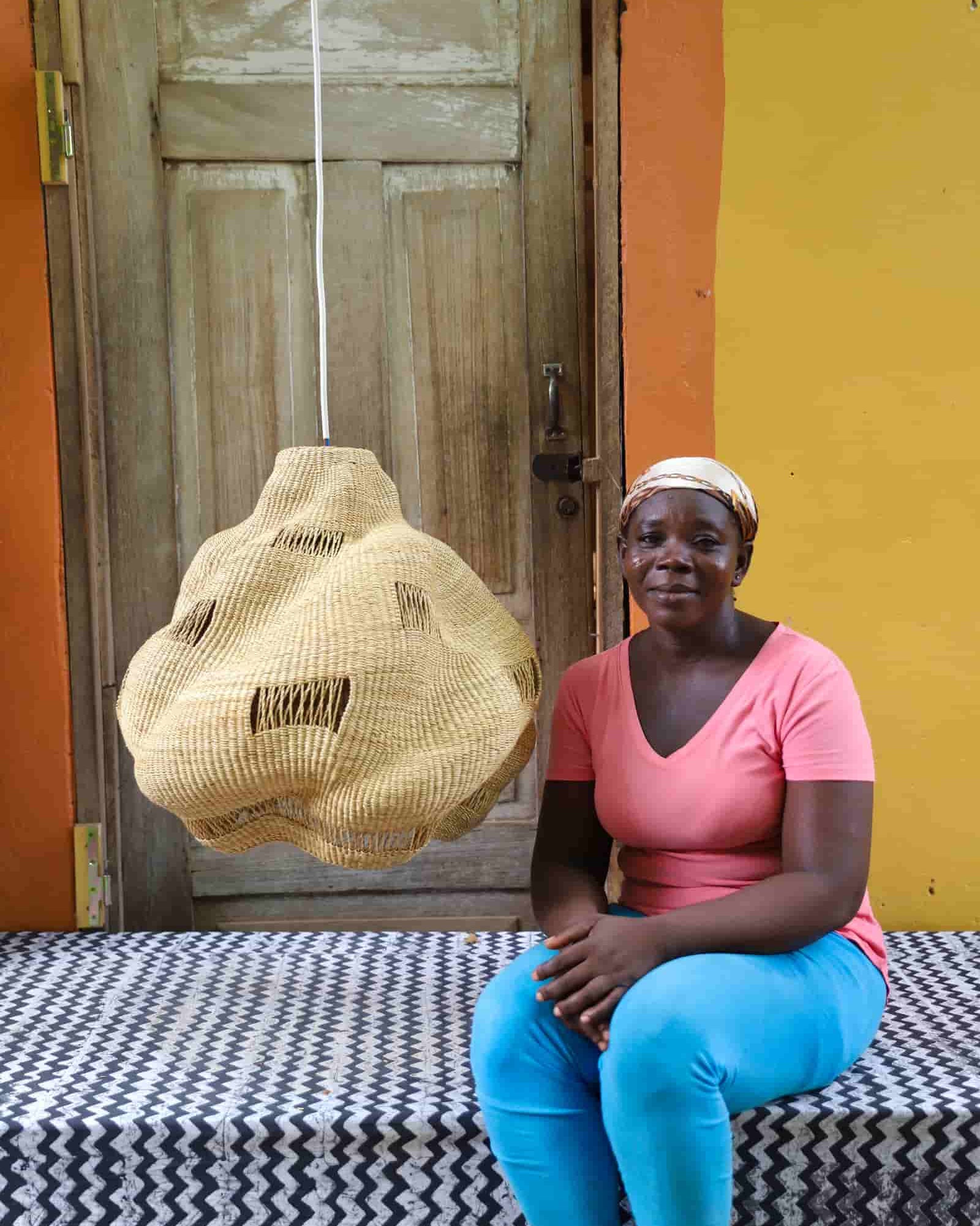 Woman sitting on a bench with a colorful background and woven basket.