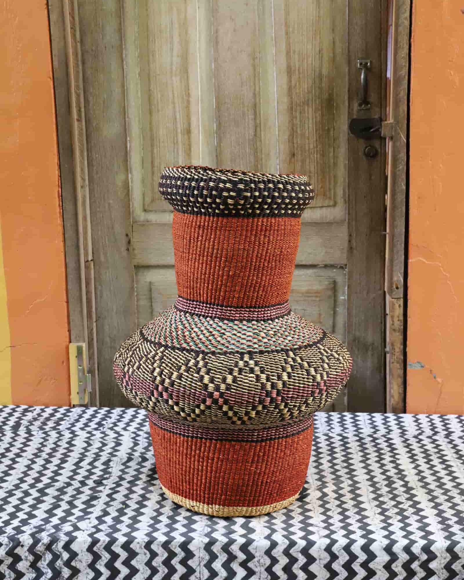 Colorful, woven décor piece on a black and white cloth against a wooden door