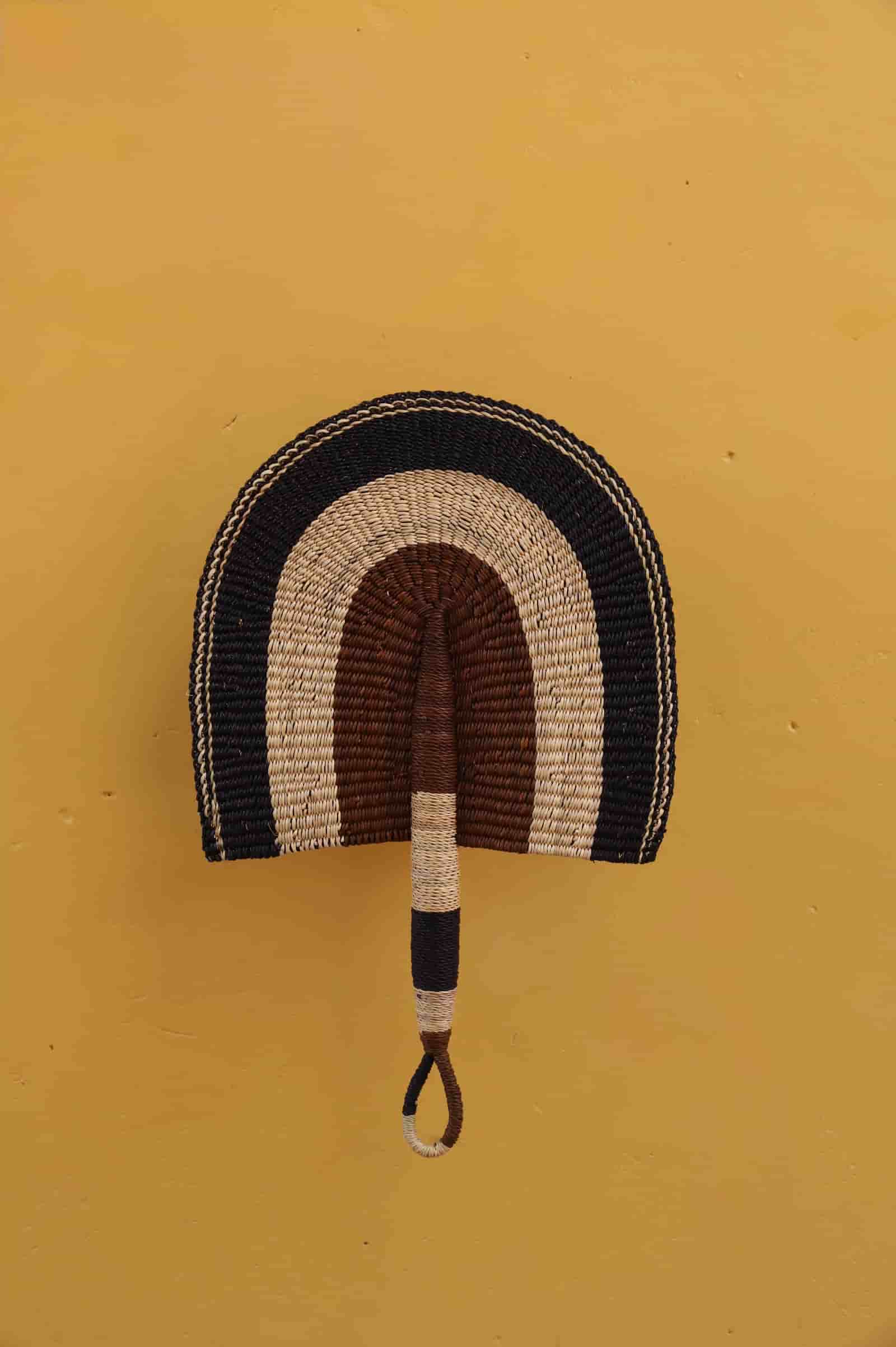 Decorative wall hook with rainbow pattern on a mustard yellow background