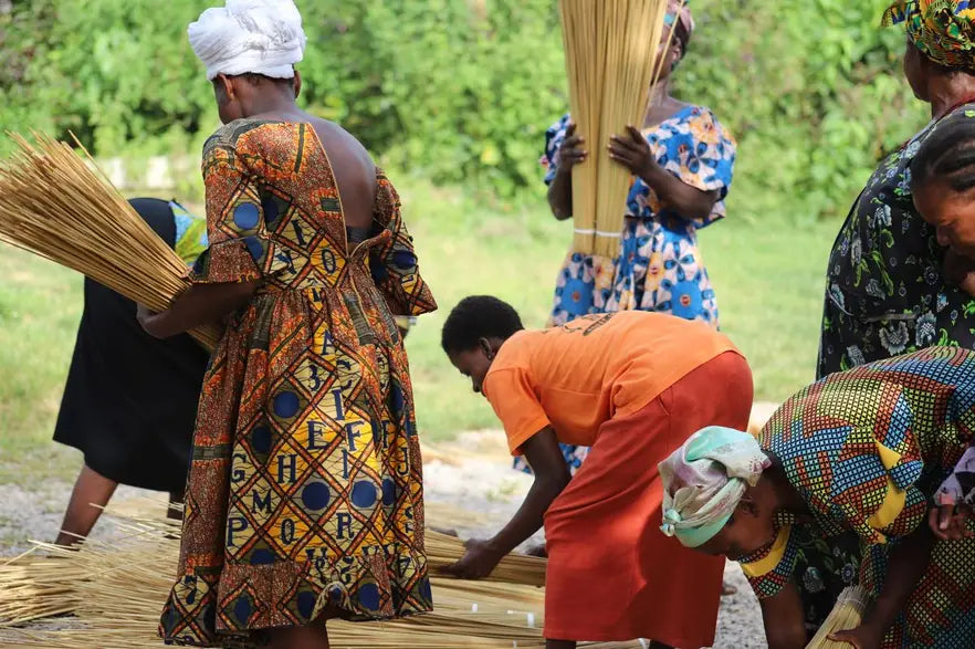 Basket makers inspecting bundles of straw at the compound