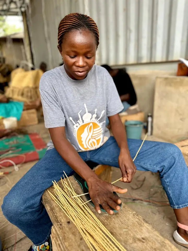 A basket maker rolling straw on a bench