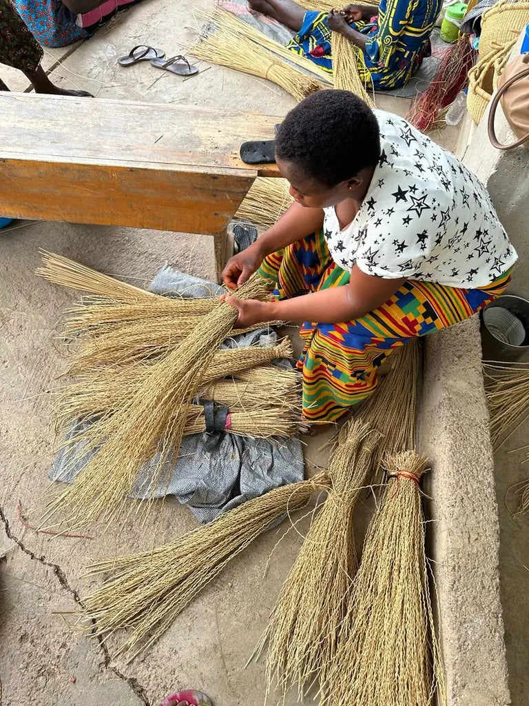 A basket maker preparing bundles of straw at the compound