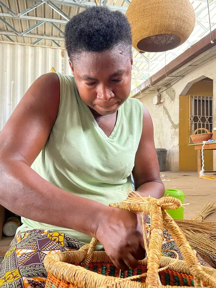 A basket maker shaping a straw handle by hand
