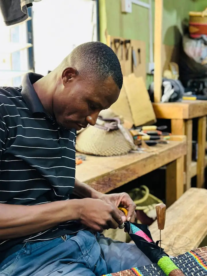 A leather worker shaping and attaching leather to a basket