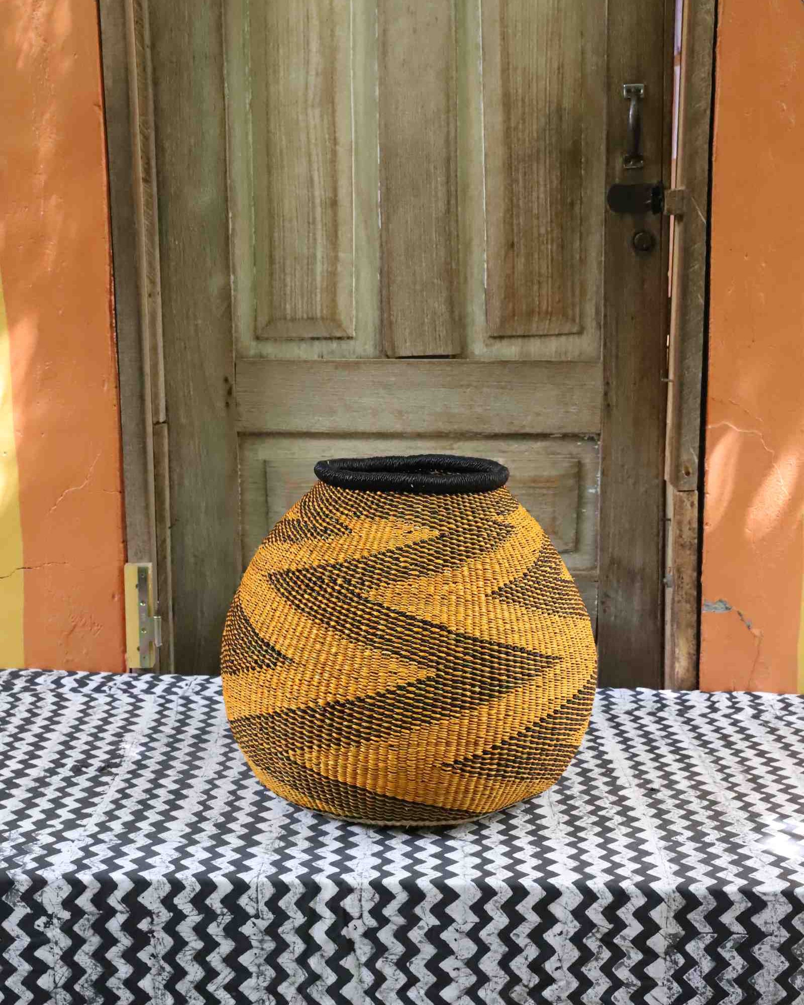 Wide round handwoven Bolga basket with vibrant geometric diamond pattern