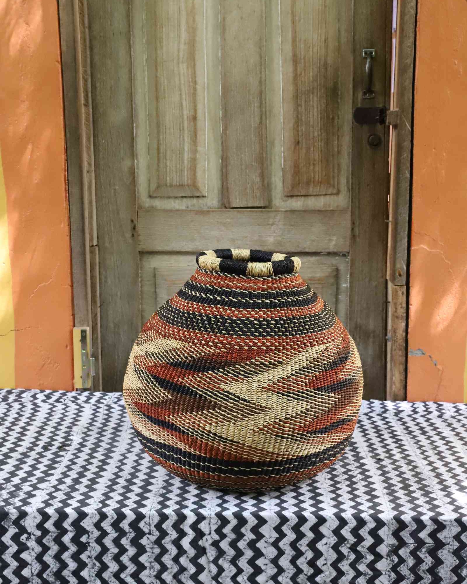 Round handwoven Bolga basket with traditional geometric woven pattern