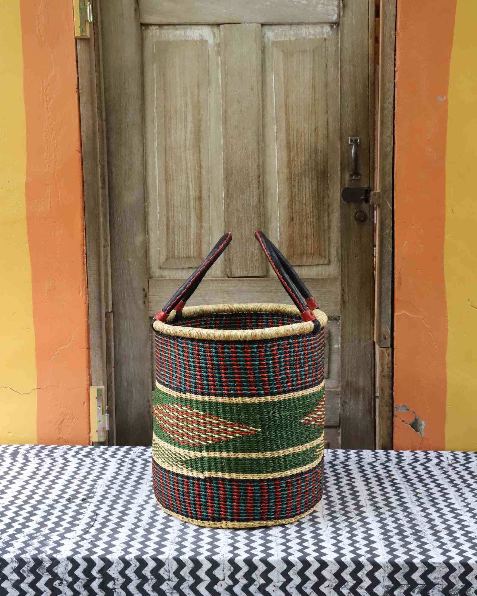 Handwoven Bolga laundry basket in elephant grass with an open top and hand-coiled form.