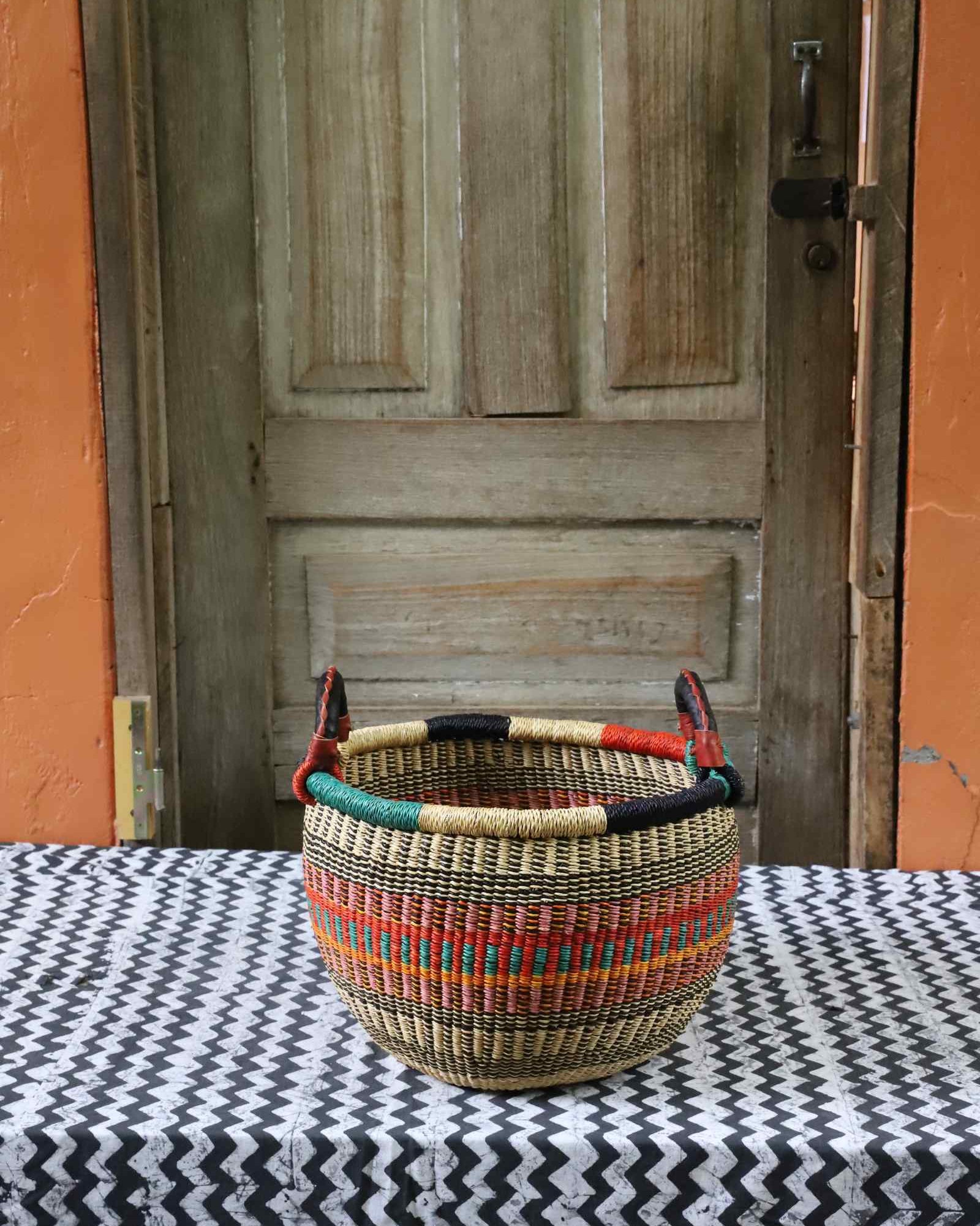 Small round handwoven Gbenka storage basket with leather handle