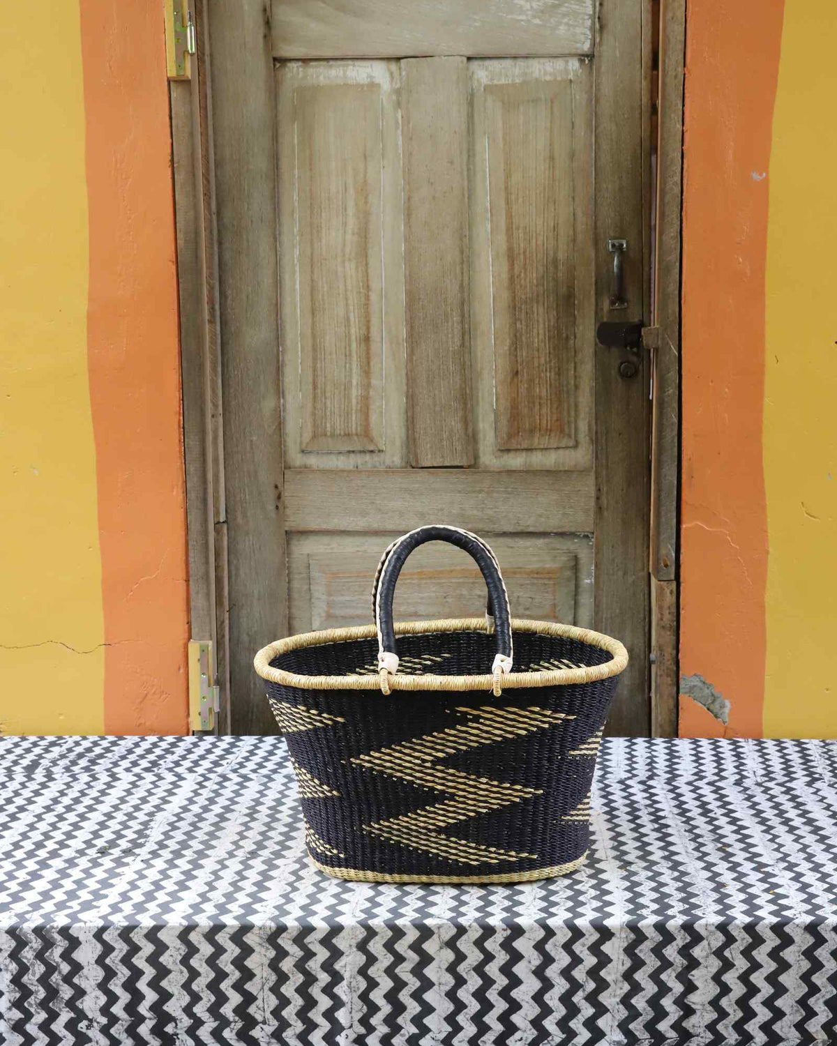 Large handwoven Bolga Zaane Tia market basket in dyed black with a natural straw zigzag weave pattern.