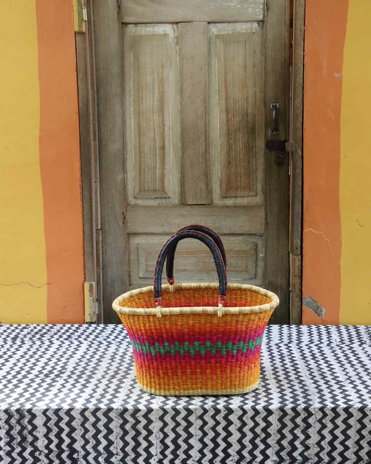 Large handwoven Bolga Zaane Tia market basket in natural straw with multicolour rainbow banded stripes.