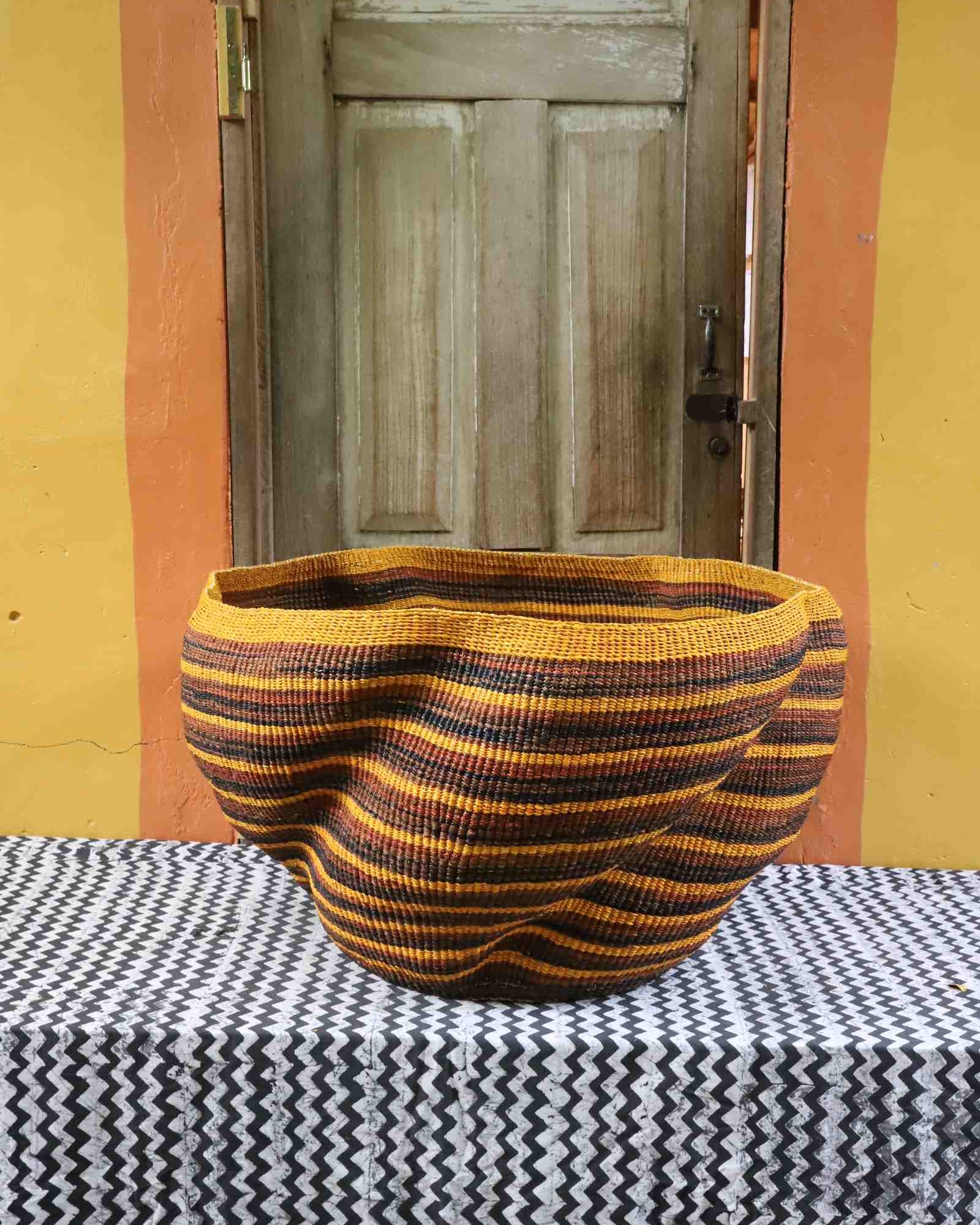 Sculptural wave-shaped handwoven Bolga art basket in natural grass