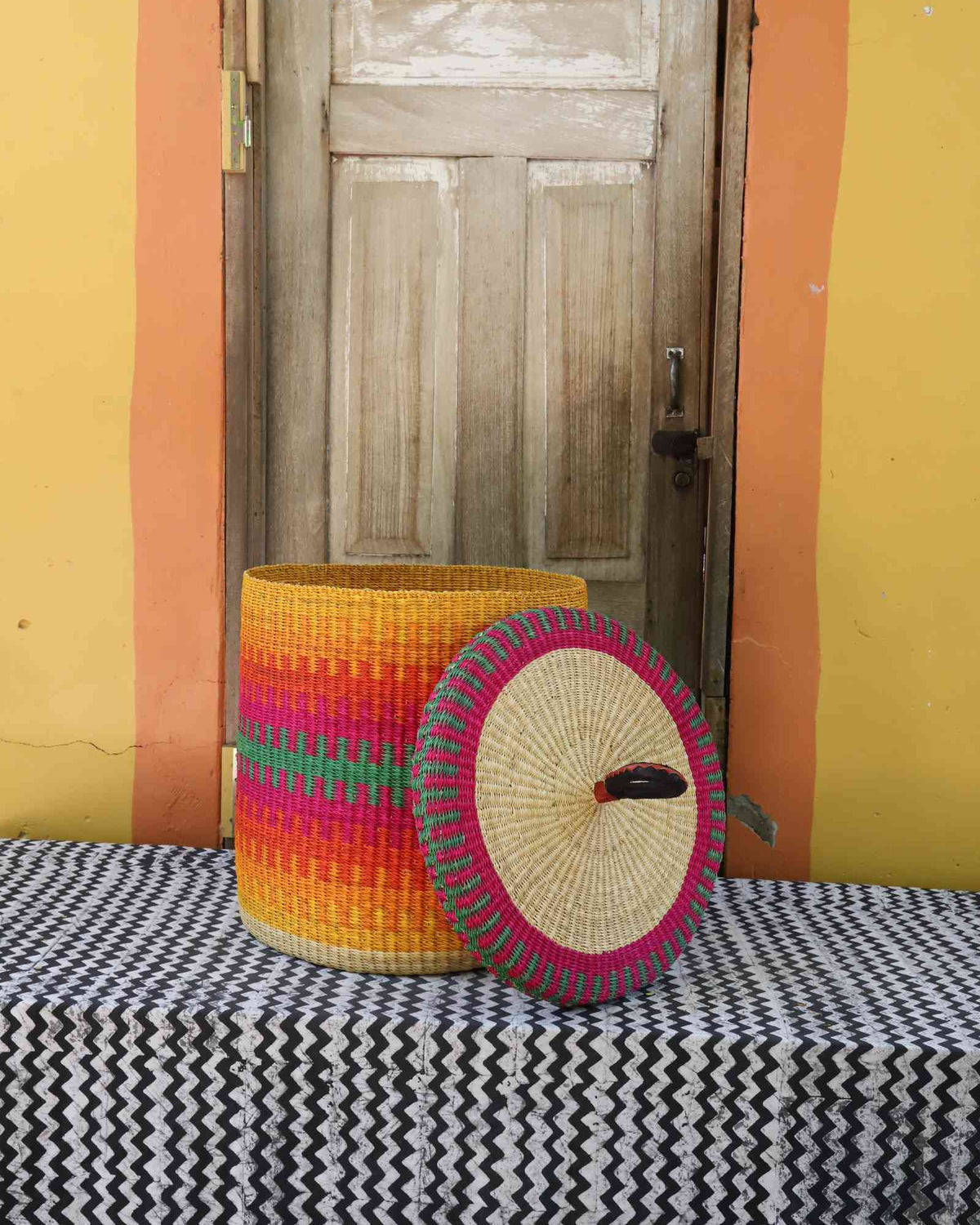 Handwoven Bolga laundry basket with lid removed, fine multicolour striped body with matching lid.