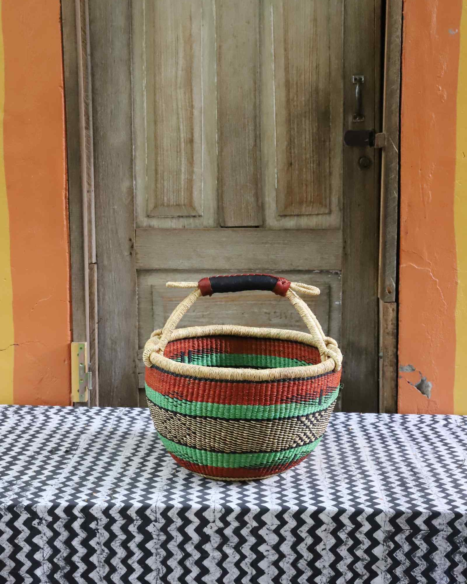 Medium round Bolga basket handwoven in elephant grass, standing 28 cm tall.