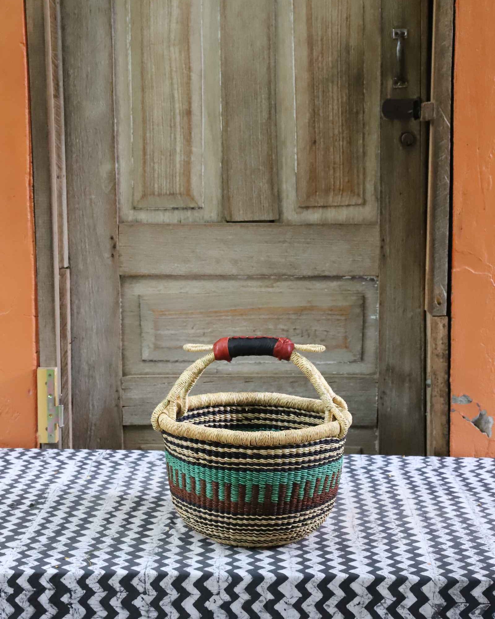 Round shopping basket, a handwoven Bolga basket in elephant grass with two handles.