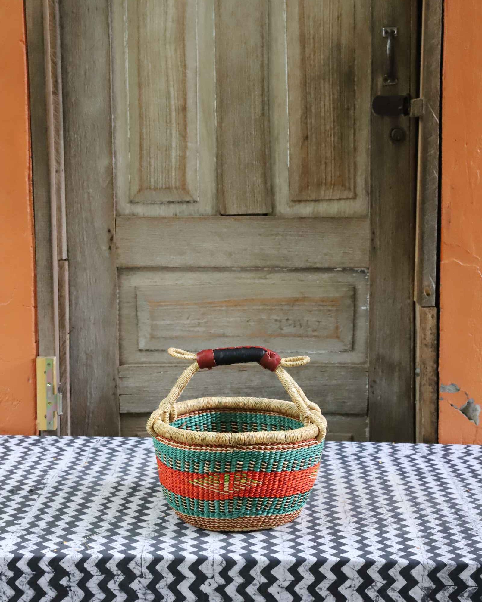 Handwoven African basket in elephant grass, round shopping form with paired handles.