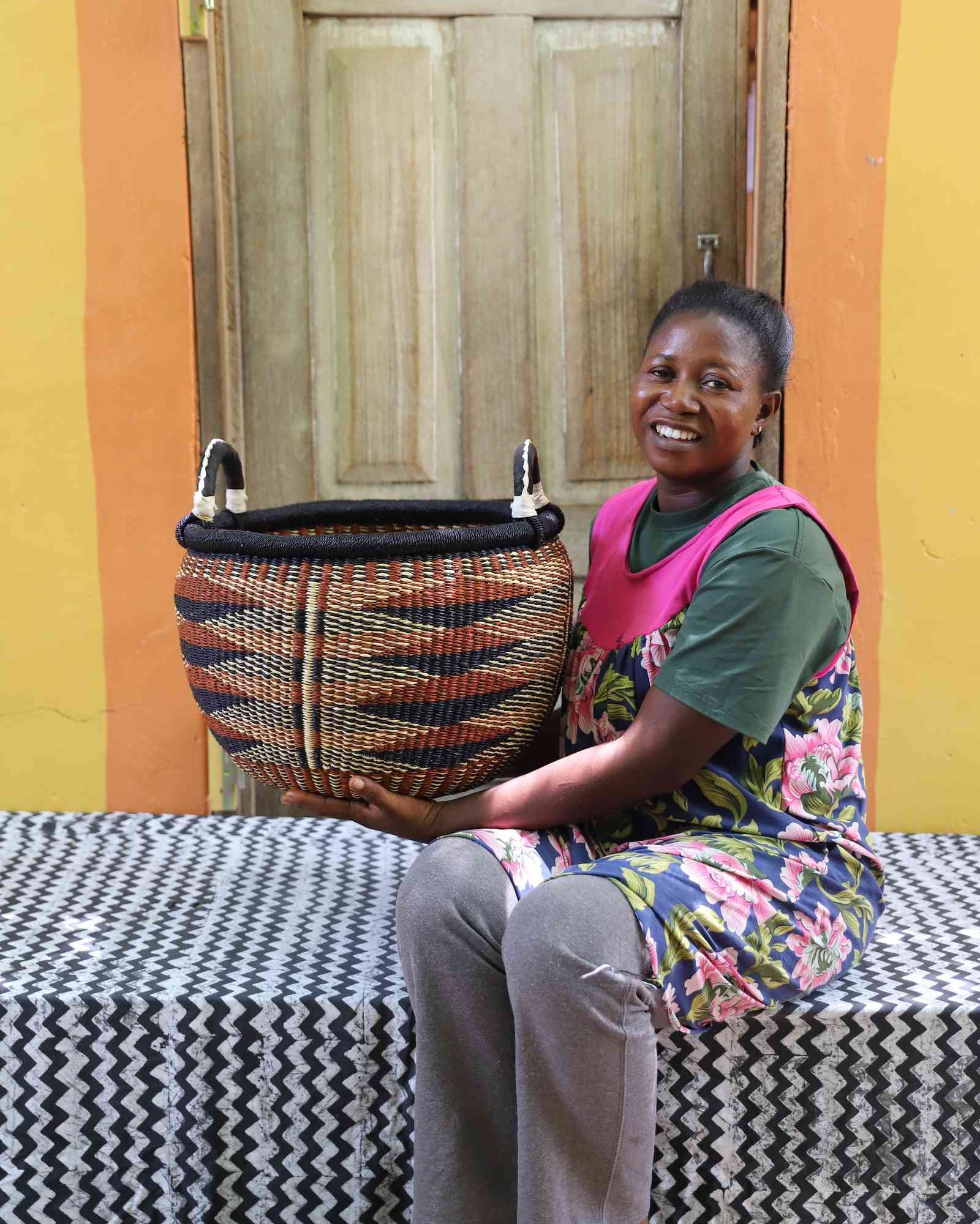 Large handwoven Gbenka storage basket displayed in a home setting
