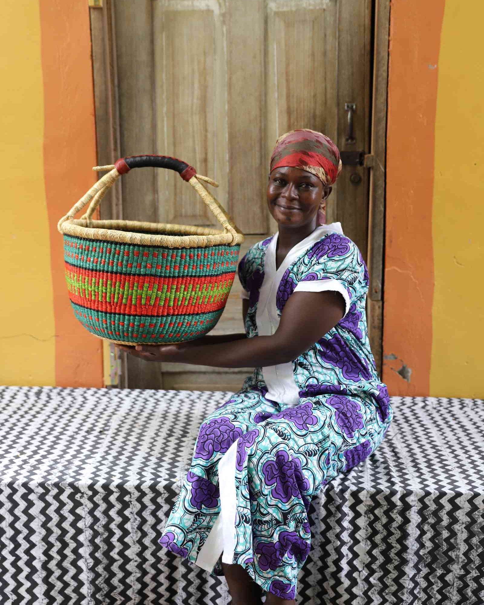 Large handwoven African basket in elephant grass, round and open with two handles.