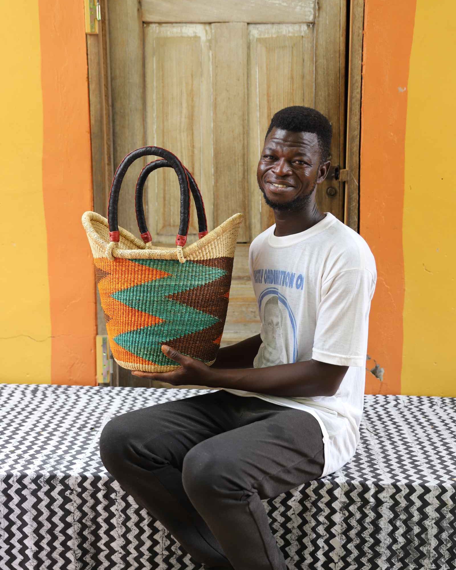 Handwoven African basket carryall in elephant grass, with two handles and a coiled rim.