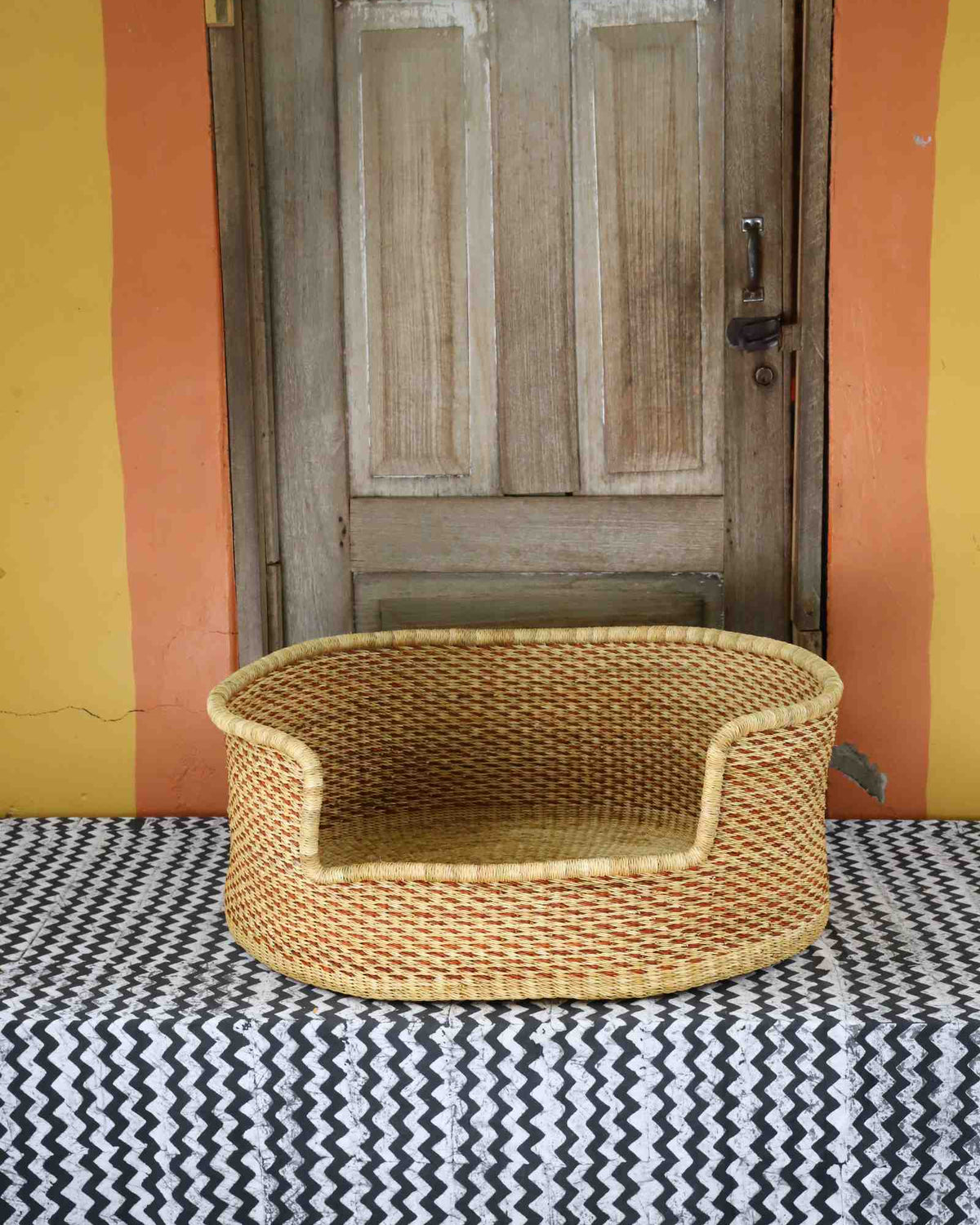 Large handwoven Bolga pet bed in plain natural straw with a subtle diagonal weave.