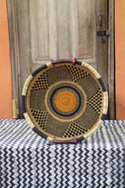 Woven basket on a table with black and white cloth a wooden door in the background