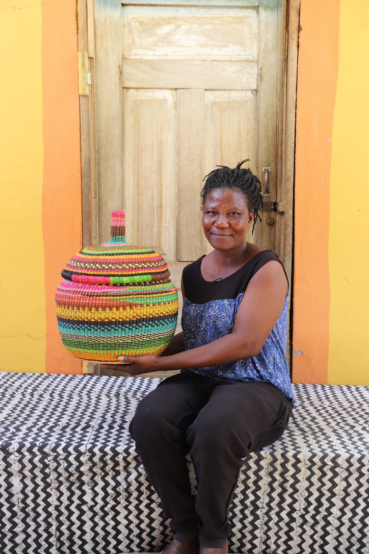 Woman holding medium Orbit storage basket in bright multicolour stripe bands