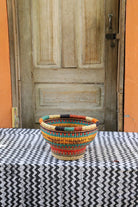 Colorful woven basket on a table with a wooden door in the background