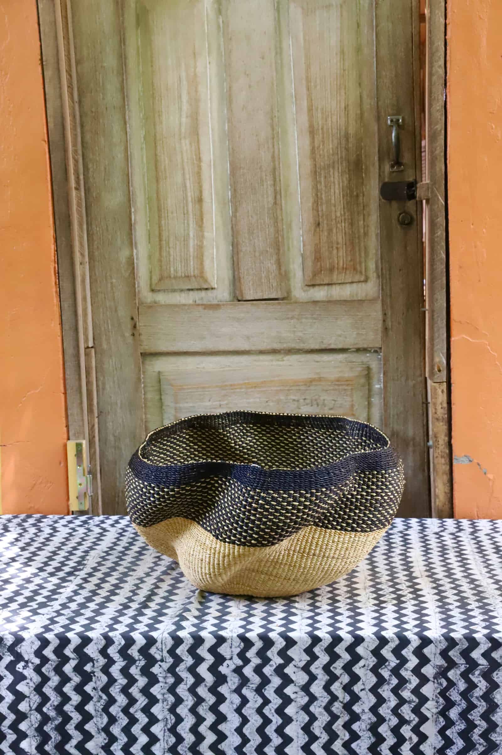 Woven basket on a table with a wooden door in the background