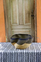 Woven basket on a table with a wooden door in the background