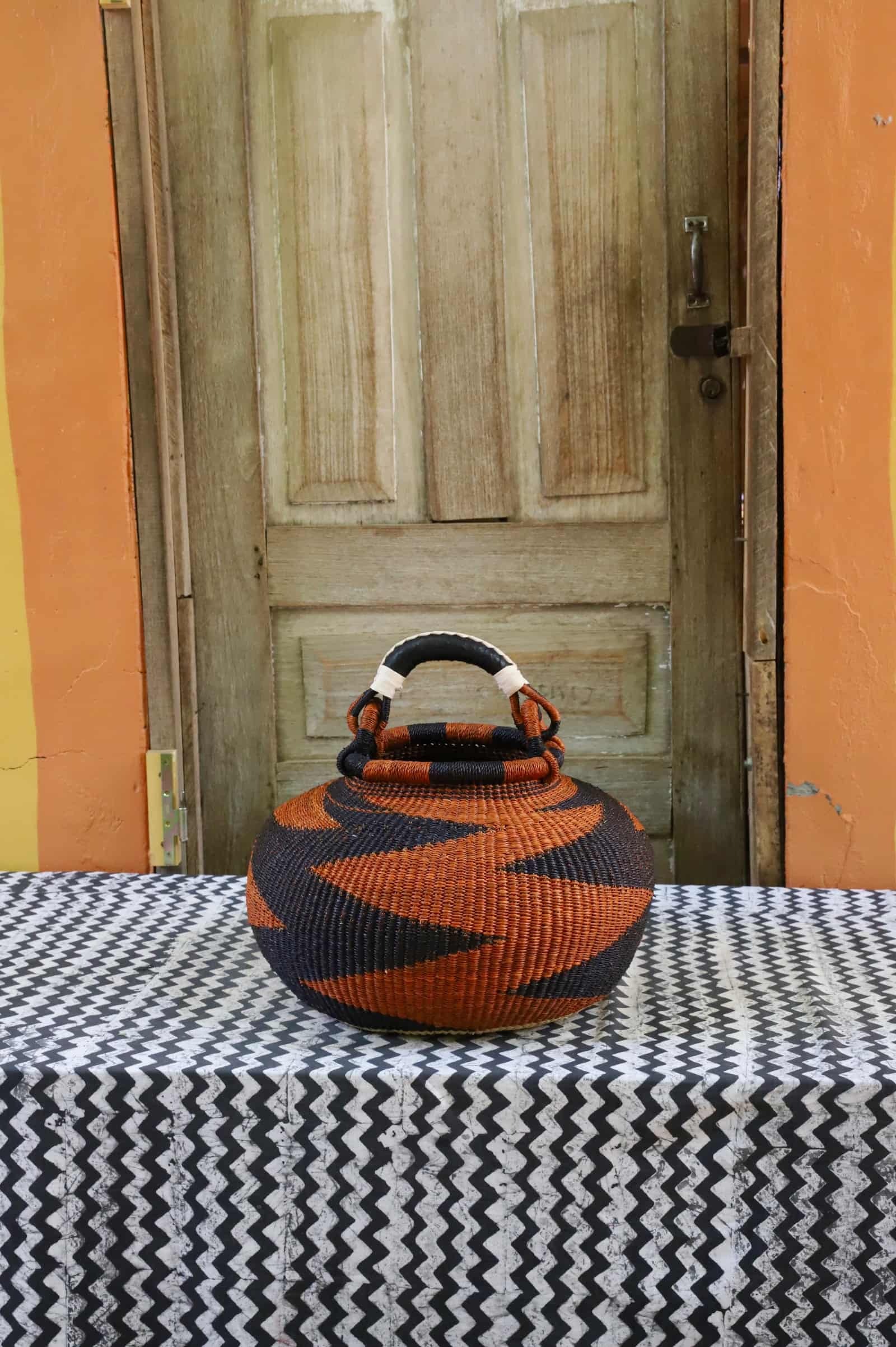 Large pot storage basket in deep rust and black bold zigzag pattern, black leather handle