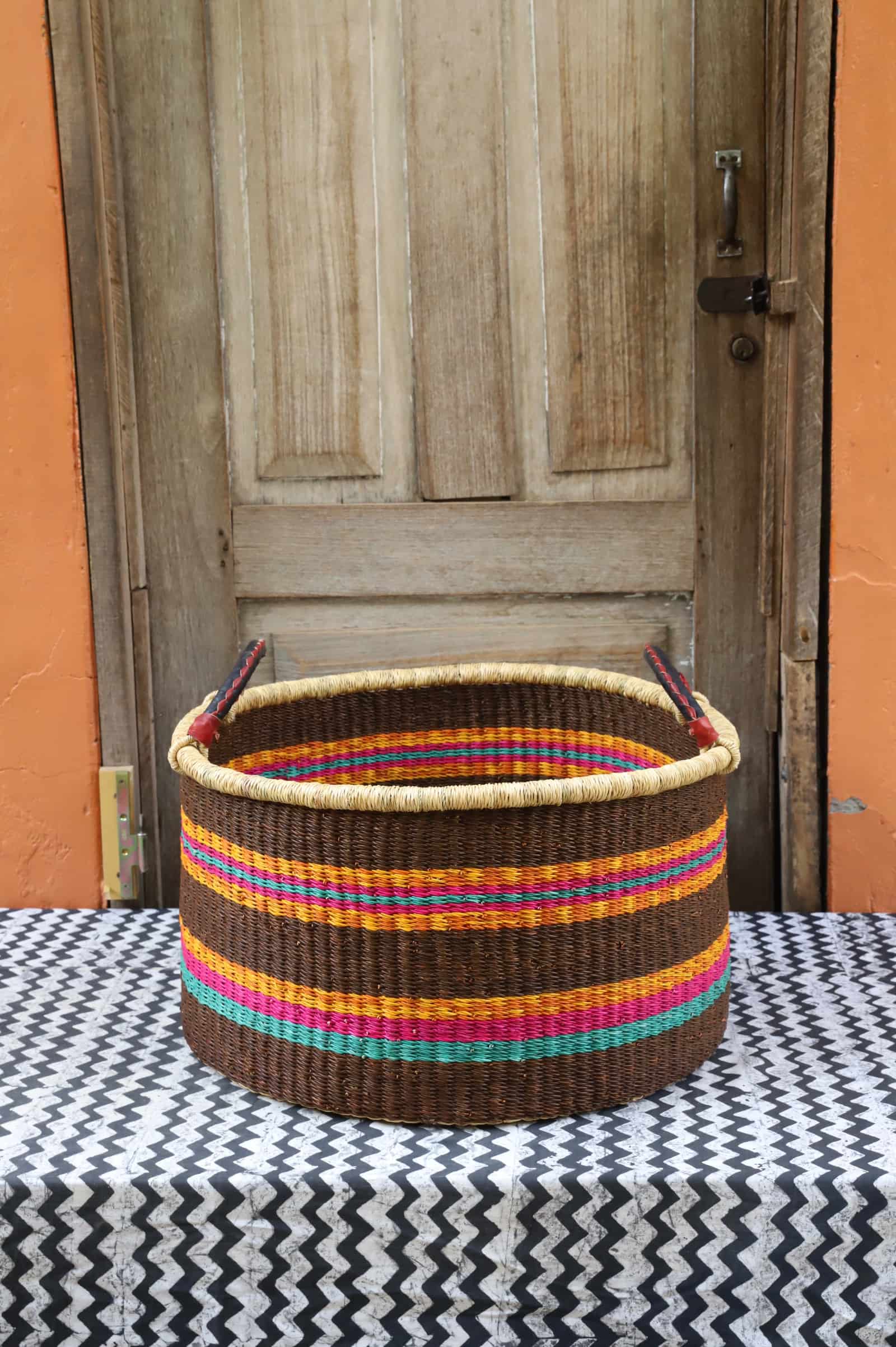 Woven Tub (Large) handwoven in Ghana sitting on black and white cloth with wooden door background
