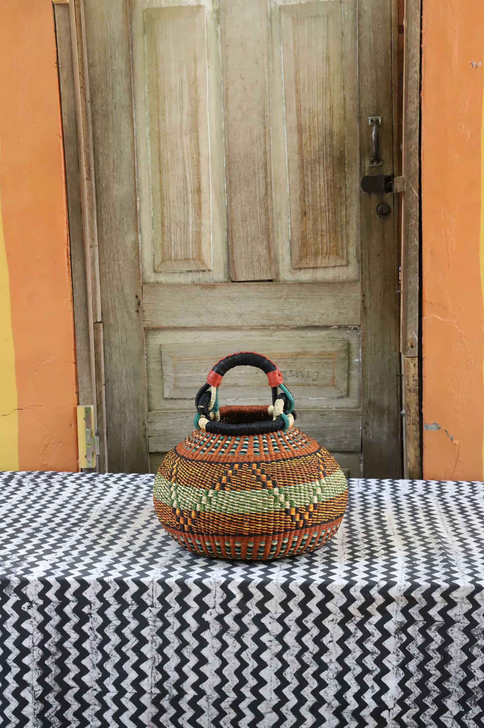Medium pot storage basket in orange and black dot pattern with teal trim and wrapped handle