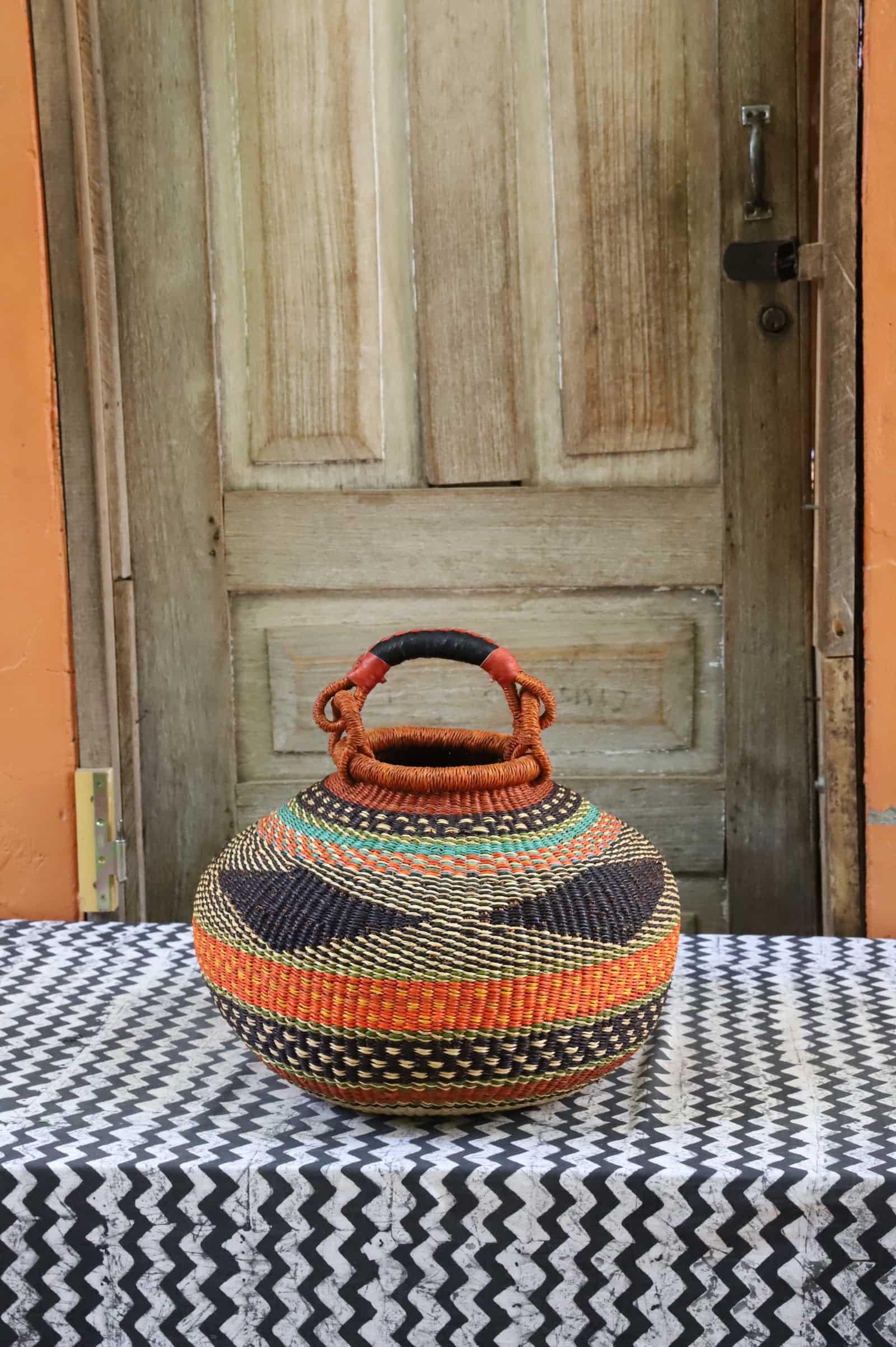 Large pot storage basket with multicolour bands — orange, teal, navy and green, terracotta handle