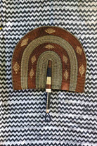 Naba Penga wall décor: brown and cream rainbow arch with diamond motifs, flat lay