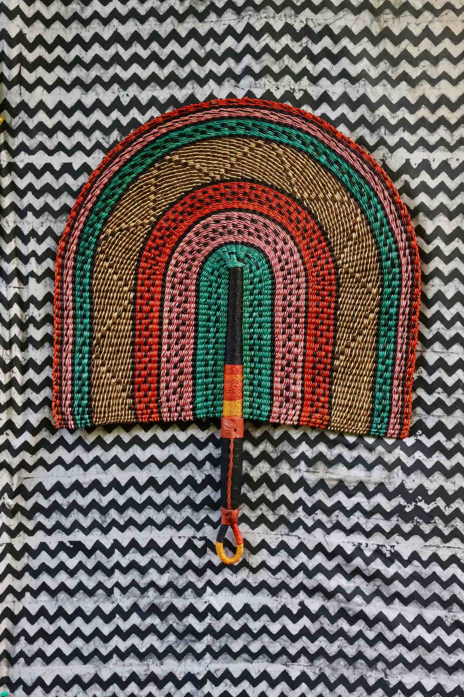Naba Penga wall décor: teal, terracotta and pink rainbow arch, flat lay on chevron fabric