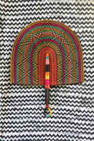 Naba Penga wall décor: burgundy rainbow arch with multicolour spot pattern, flat lay
