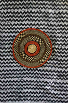 Large woven placemat with terracotta outer rim, black and natural checkered mid-band
