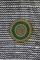 Large woven placemat in forest green with orange accent ring and natural straw border