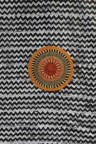 Small woven placemat with terracotta and olive radial pattern, natural straw outer ring