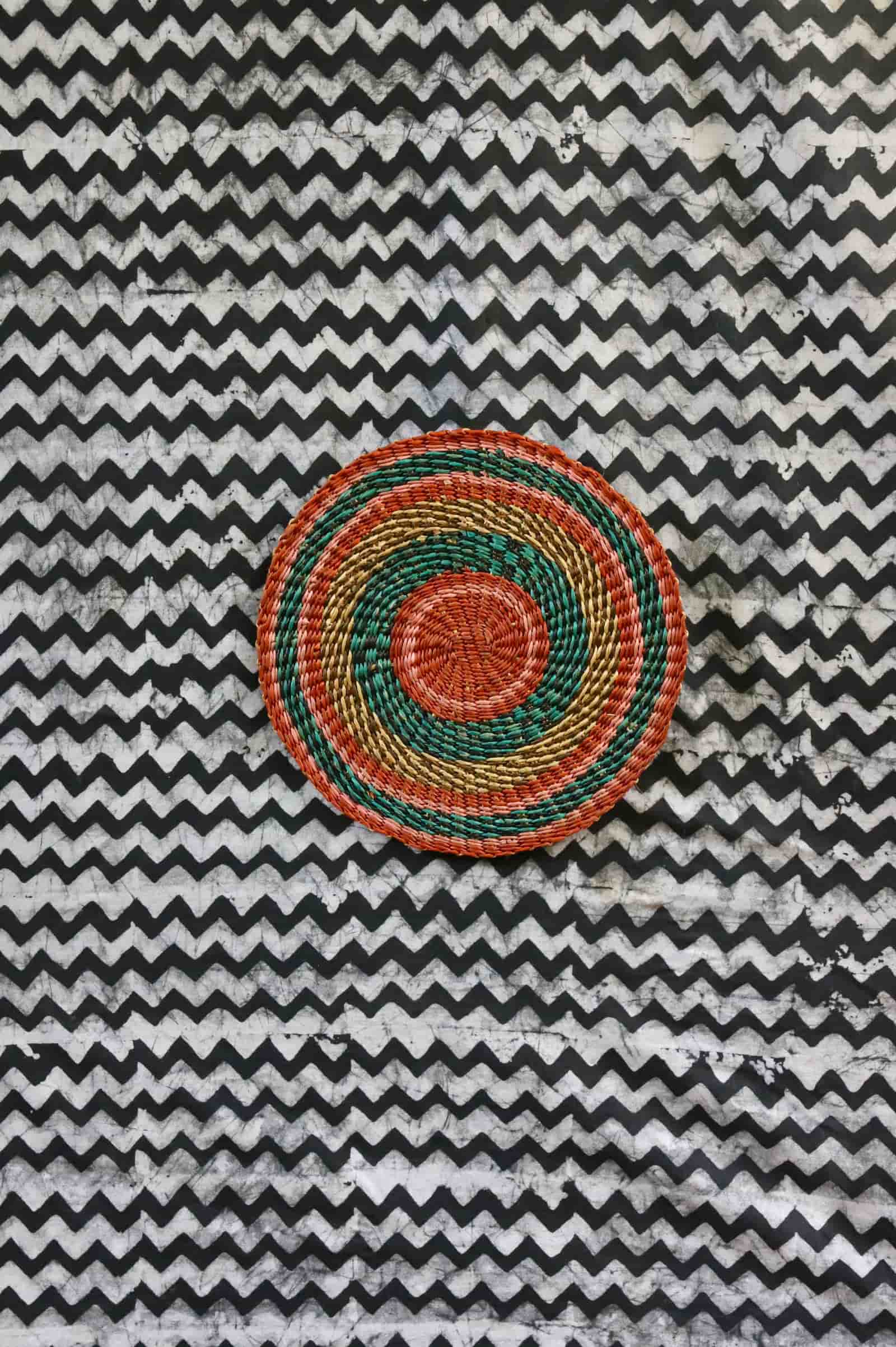 Small woven placemat with terracotta centre, teal ring and gold outer band